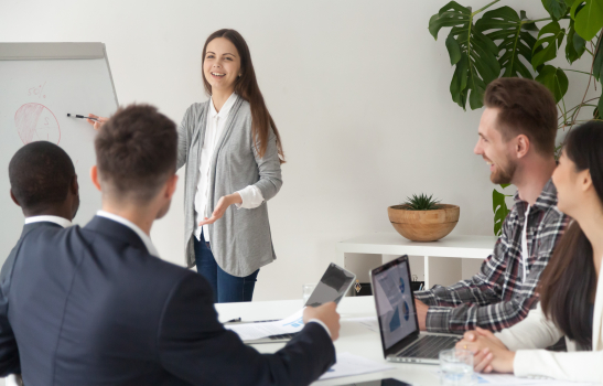 Souriant jeune employé donnant présentation travaillant avec un tableau à feuilles mobiles dans la salle de réunion 