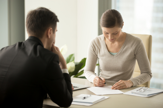 Femme d'affaires signant un contrat avec un homme d'affaires