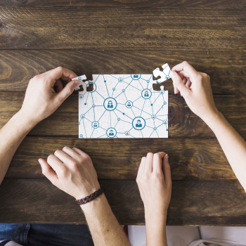 Femme et homme, résoudre le puzzle de la connectivité réseau sur un bureau en bois