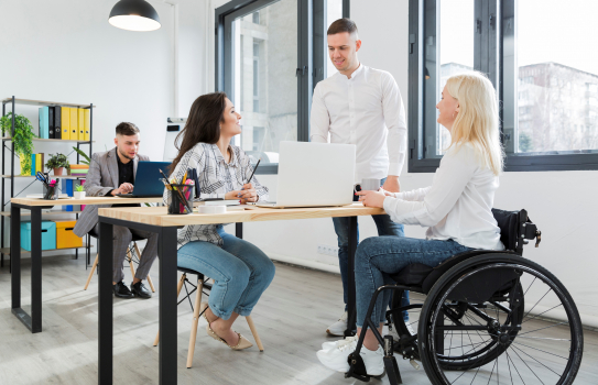 Femme en fauteuil roulant au bureau avec des collègues